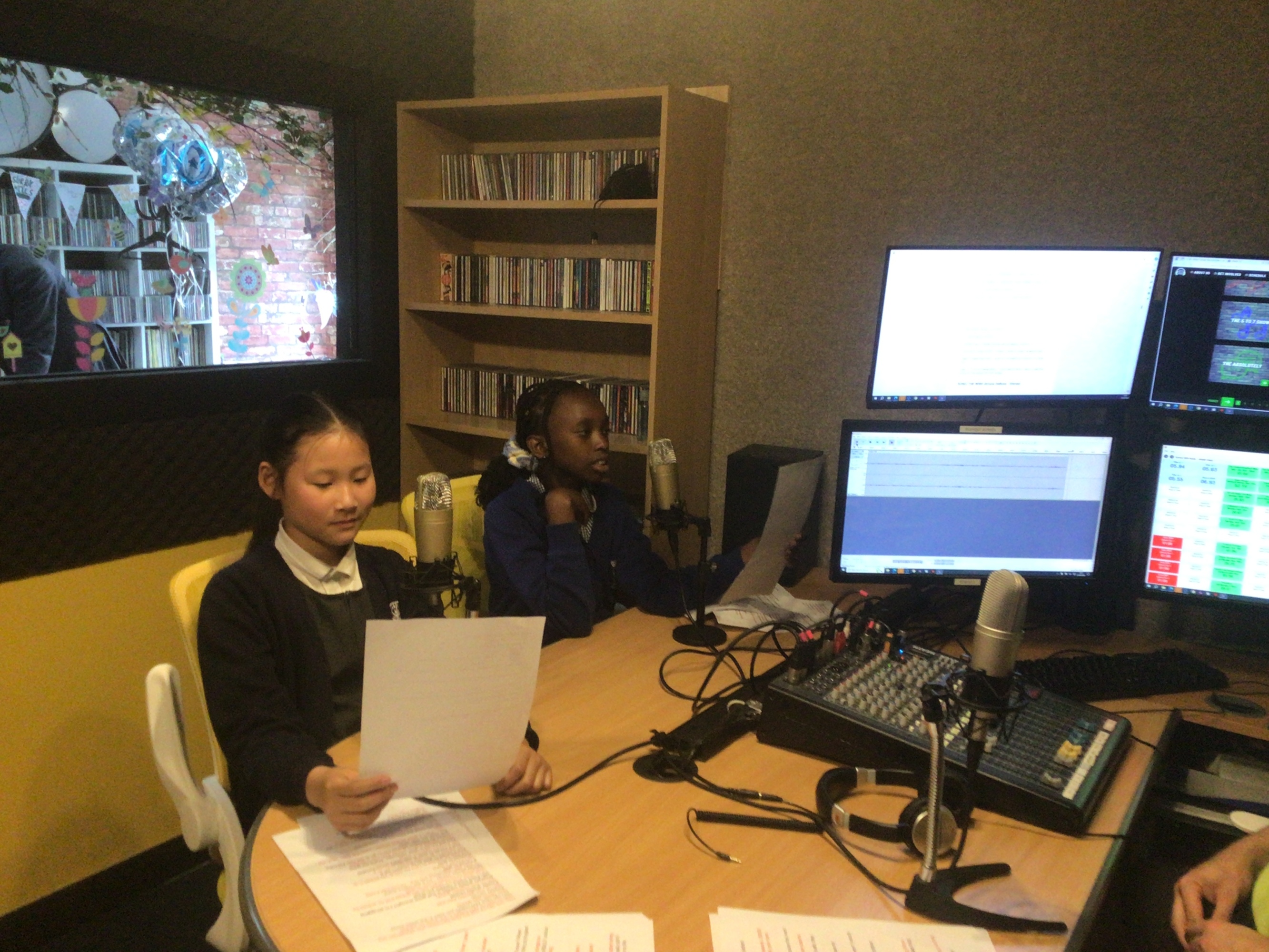 Pupils reading a script in the radio studio